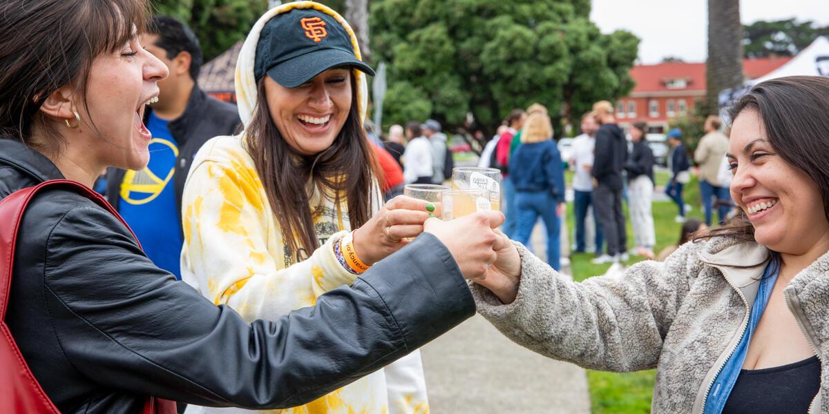 Three female friedns cheersing a beer