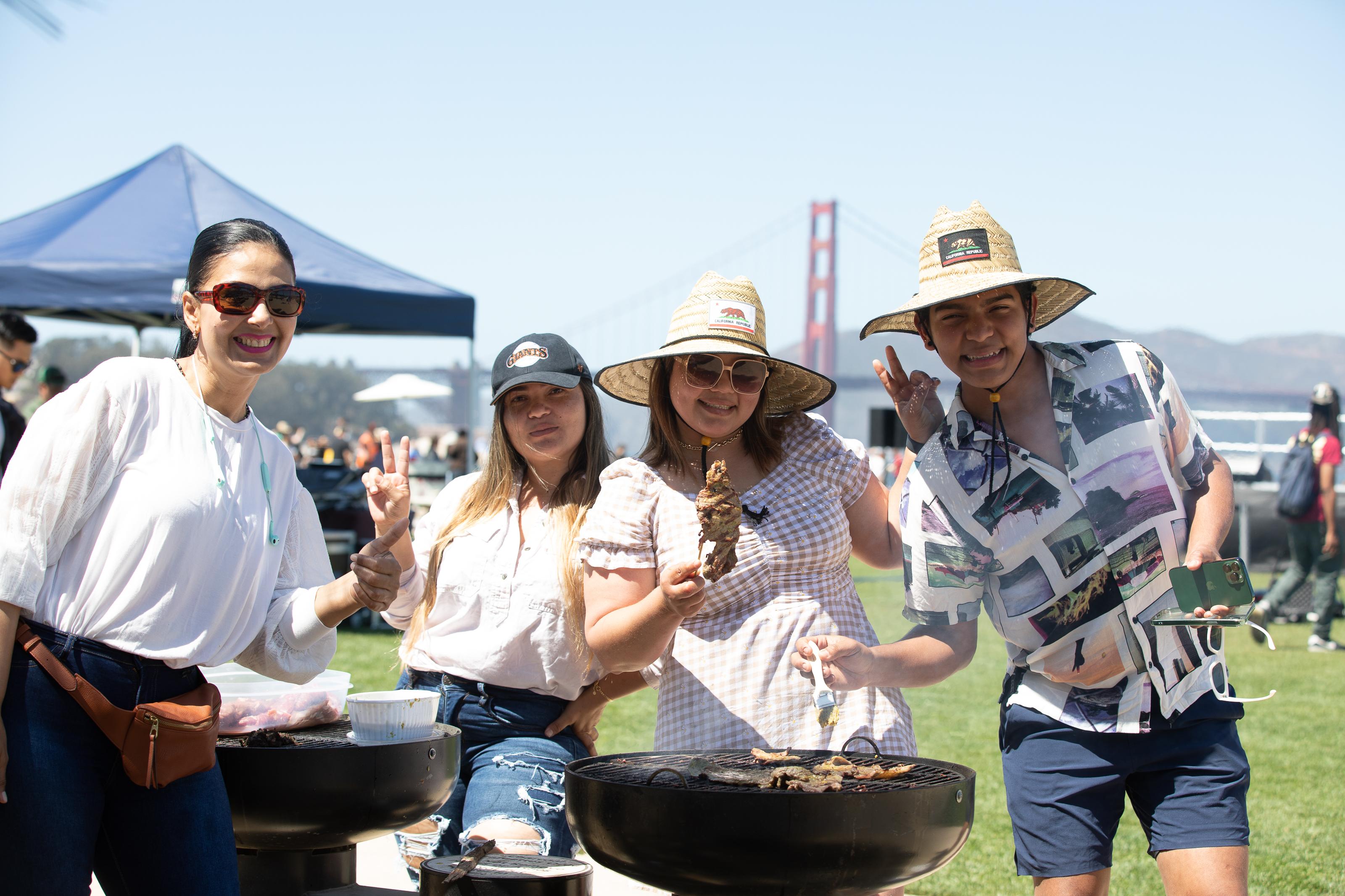 People grilling out in front of the golden gate bridge.