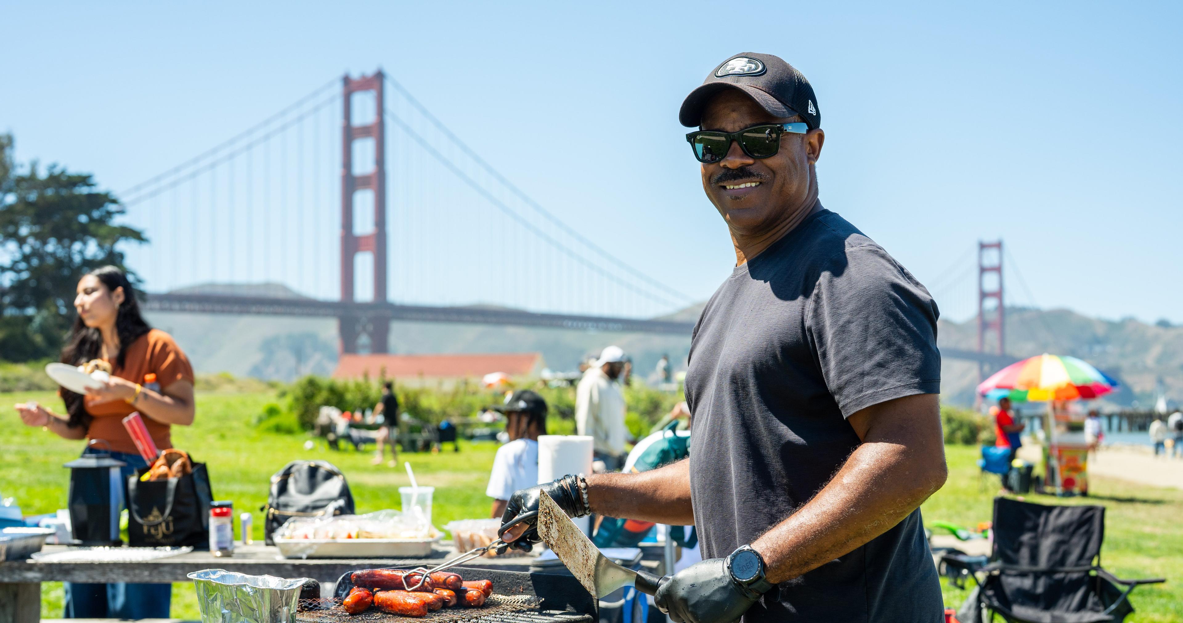 Man grilling at Crissy Field with the Golden Gate Bridge in the background