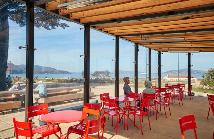Bright red chairs at the sheltered pavilion next to Presidio Transit Center. .